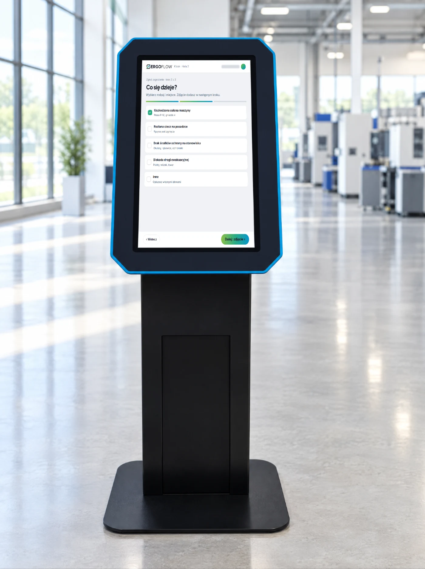 Kiosk w hali, na ekranie: zgłoszenie zagrożenia.